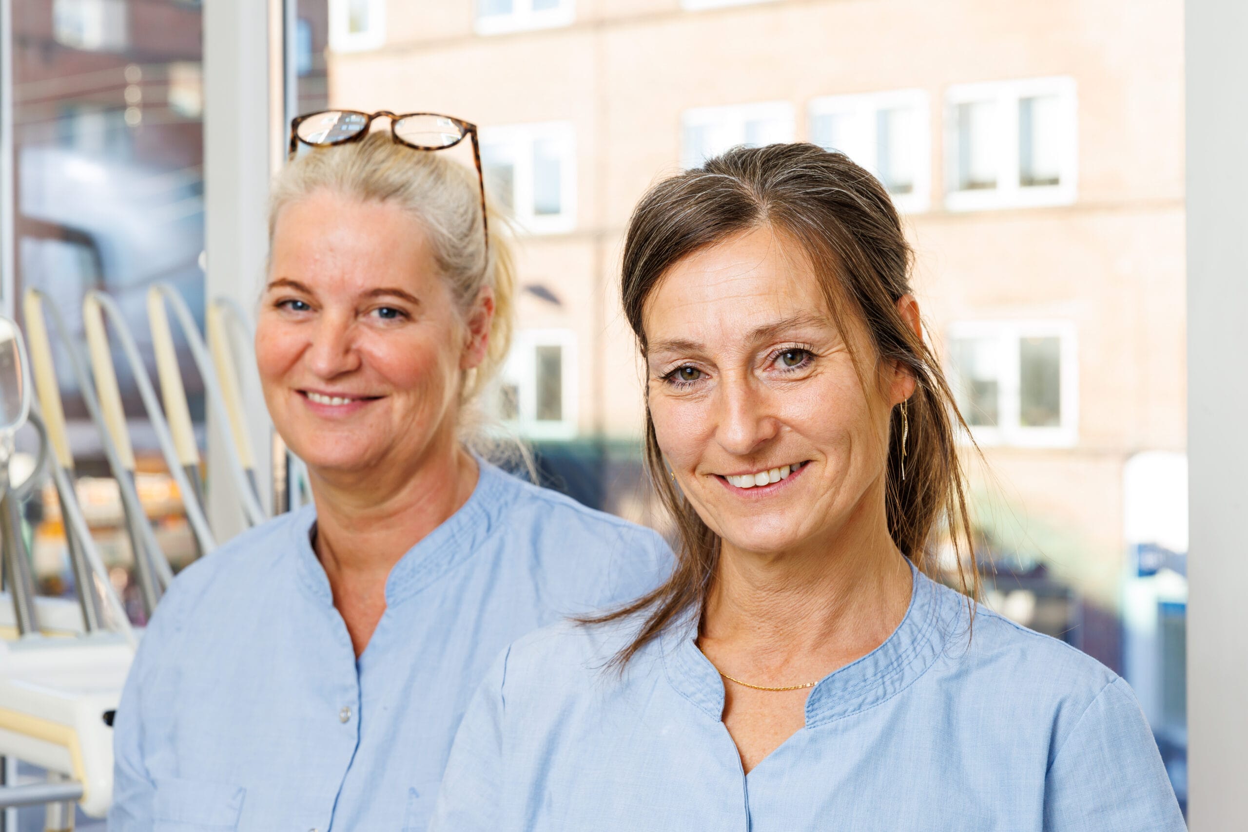 To smilende kvinder i lyseblå uniformer