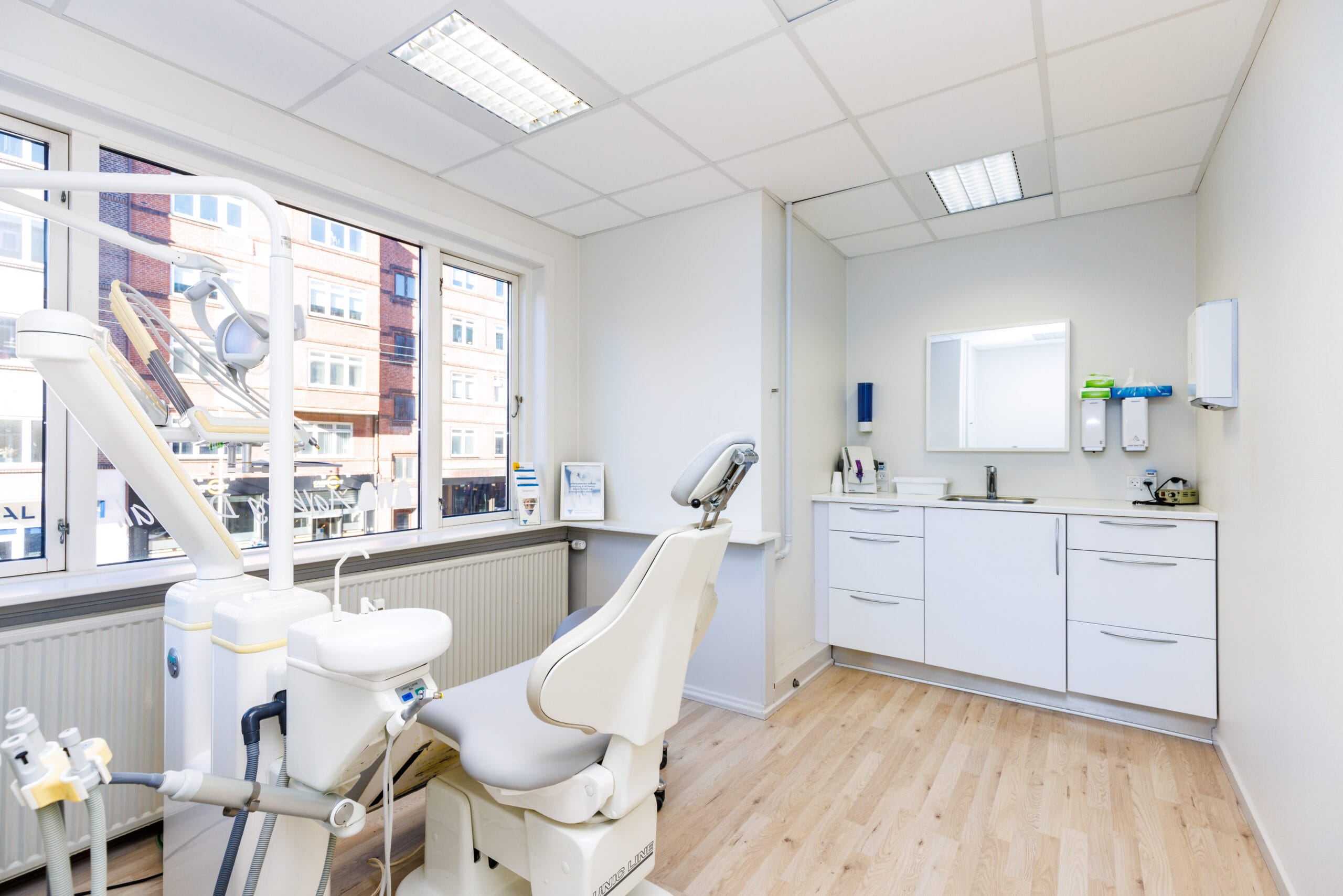Moderne tandlægeklinik med tandlægestol og udstyr.