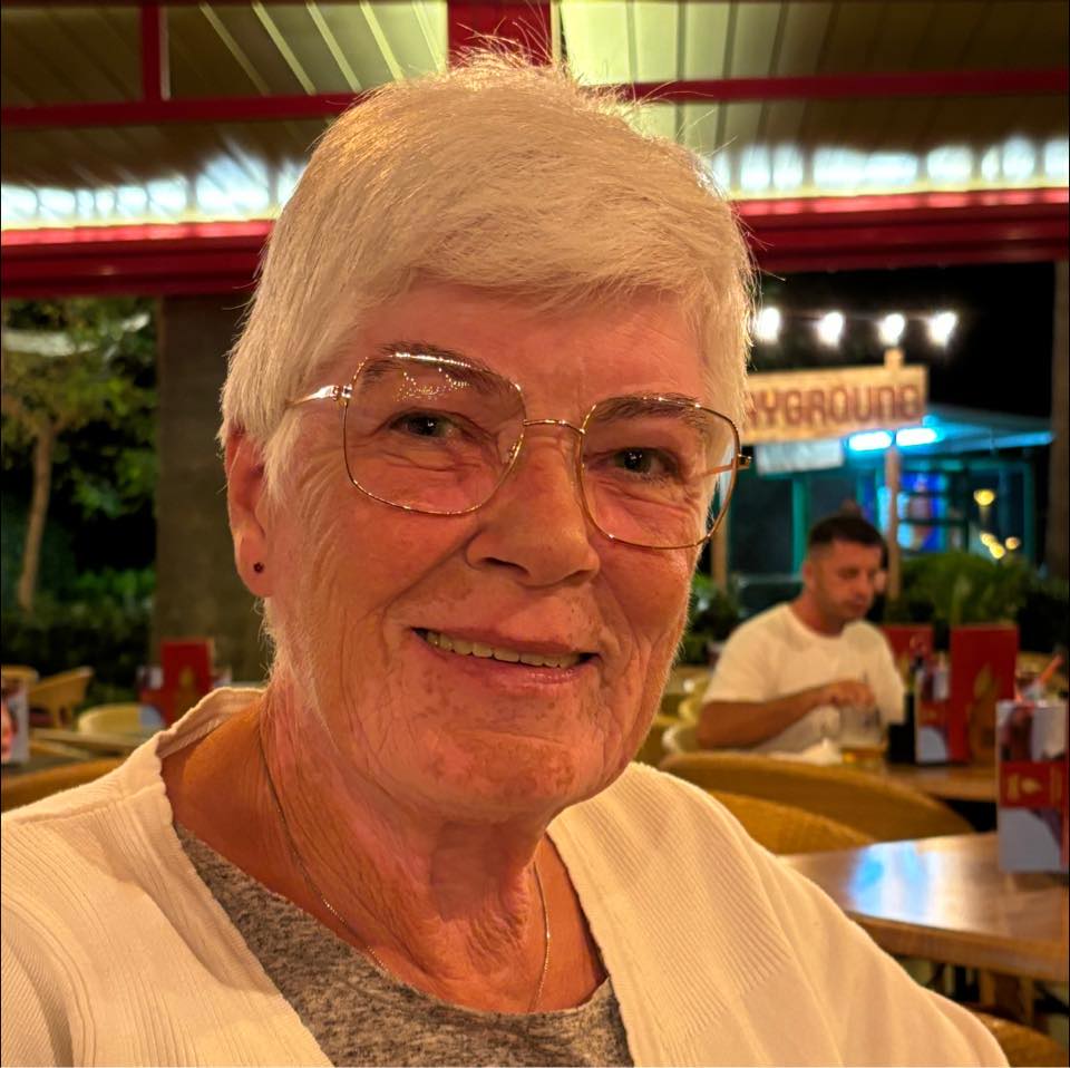 Ældre kvinde smiler på en restaurant.